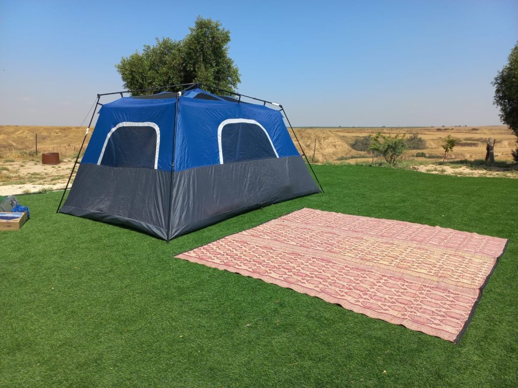 אוהל קמפינג פרוס על מדשאה במתחם הקמפינג בחוות הדקלים בנגב